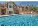 Community swimming pool with pristine blue water surrounded by lounge chairs and beautiful building exteriors at 8726 S Kline St # A208, Littleton, CO 80127