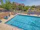 Community pool with crystal clear blue water, lounge chairs, and surrounding neighborhood at 8726 S Kline St # A208, Littleton, CO 80127