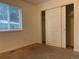 Bedroom with window, closet and neutral carpeting offers a serene and comfortable space at 894 S Krameria St, Denver, CO 80224