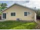 View of the house's back exterior with a yellow siding and a well maintained lawn at 894 S Krameria St, Denver, CO 80224