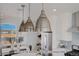 Kitchen features pendant lighting, white shaker cabinets and a stainless steel refrigerator at 2732 W 68Th Ave, Denver, CO 80221
