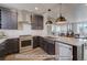 Modern kitchen with dark cabinetry, stainless steel appliances, and farmhouse sink at 2732 W 68Th Ave, Denver, CO 80221