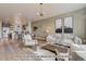 Open living room features hardwood floors, modern furniture, and a kitchen with island at 2732 W 68Th Ave, Denver, CO 80221