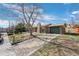 Charming brick home featuring a green garage door and a tree-lined front yard at 6779 W 79Th Cir, Arvada, CO 80003