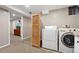 A well-lit laundry room featuring a washer, dryer, and access to an adjacent room, providing convenience and functionality at 6779 W 79Th Cir, Arvada, CO 80003
