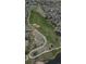 Scenic aerial view showcases a golf course home with a serene pond, manicured fairways, and nearby residential areas at 7713 S Zante Ct, Aurora, CO 80016