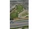 An aerial view of the golf course with a long green fairway and sand traps lining the sides at 7713 S Zante Ct, Aurora, CO 80016