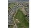 Aerial view of a golf course neighborhood, showcasing lush green fairways, sand traps, and surrounding houses at 7713 S Zante Ct, Aurora, CO 80016