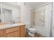 Bright bathroom with a vanity, toilet, and shower-tub combo with white tile surround and a shower curtain at 7713 S Zante Ct, Aurora, CO 80016
