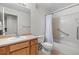 Bathroom featuring a single sink vanity, toilet, and shower-tub combination with safety bars at 7713 S Zante Ct, Aurora, CO 80016