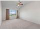 Spacious bedroom featuring neutral carpet, a large window with a view, and a ceiling fan at 7713 S Zante Ct, Aurora, CO 80016