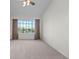 Bright bedroom with a vaulted ceiling, large window with a picturesque view, and neutral carpet at 7713 S Zante Ct, Aurora, CO 80016