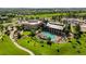 Aerial view of a clubhouse and pool surrounded by green lawns and mature trees in a golf course community at 7713 S Zante Ct, Aurora, CO 80016