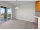 Dining room with carpet, sliding glass doors to a balcony, a modern chandelier and a pass through to the kitchen at 7713 S Zante Ct, Aurora, CO 80016