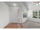 Bright entry way with a wood-look floor, a white front door, and large windows providing natural light at 7713 S Zante Ct, Aurora, CO 80016