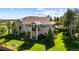 Spacious multi-story home with stone accents, a balcony, a well-maintained lawn and mature trees at 7713 S Zante Ct, Aurora, CO 80016