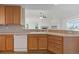 Well-lit kitchen with ample counter space, wooden cabinets, and an open view into the living room at 7713 S Zante Ct, Aurora, CO 80016