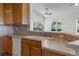 View of the kitchen with a pass through to the living area, light countertop and ample storage at 7713 S Zante Ct, Aurora, CO 80016