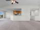 Open-concept living room with carpet, a pass-through to the kitchen and access to a balcony at 7713 S Zante Ct, Aurora, CO 80016