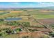Aerial view of the property showing the home, outbuildings, pond, and surrounding acreage at 10690 County Road One, Longmont, CO 80504