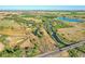 A scenic aerial view of sprawling acreage with ponds, streams, and a charming home nestled among lush greenery at 10690 County Road One, Longmont, CO 80504