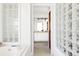 View of bathroom featuring tiled flooring, glass block wall, and double sink vanity with attractive lighting at 10690 County Road One, Longmont, CO 80504