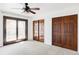 Spacious carpeted bedroom featuring dark trim, ceiling fan and access to a private balcony at 10690 County Road One, Longmont, CO 80504