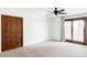 Large bedroom with carpet, ceiling fan, a sliding glass door, and wood closet doors at 10690 County Road One, Longmont, CO 80504