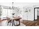 Bright dining room with hardwood floors, modern chandelier, and custom built-in shelving at 10690 County Road One, Longmont, CO 80504
