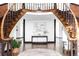 Grand foyer with a curved staircase, hardwood floors, and elegant console table at 10690 County Road One, Longmont, CO 80504