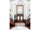 Welcoming foyer with a grand staircase, chandelier, and beautiful double doors at 10690 County Road One, Longmont, CO 80504