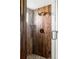 Modern shower with wood-look tile, glass door, and bronze fixtures at 10690 County Road One, Longmont, CO 80504