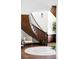 Elegant staircase features dark wood banister, white walls and floors, with sconce lighting at 10690 County Road One, Longmont, CO 80504