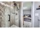 Bathroom shower boasts gray tiling, a glass door, and modern fixtures and is adjacent to the main bedroom at 3378 Mowry Pl, Westminster, CO 80031