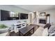 Cozy living room with two flatscreen TVs, fireplace, dark hardwood floors, light gray walls and a comfortable sofa at 3378 Mowry Pl, Westminster, CO 80031