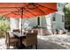 Outdoor patio with an umbrella, a gas grill, and a seating area with landscaped greenery at 1260 Hudson St, Denver, CO 80220