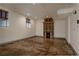 Open basement featuring polished concrete floors and a decorative fireplace, lit by natural light at 1260 Hudson St, Denver, CO 80220
