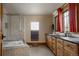Spacious bathroom with tiled shower, dual sinks, dark countertops and wood cabinets at 1260 Hudson St, Denver, CO 80220
