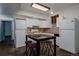 Compact kitchen with updated appliances, white cabinetry, and a cozy dining area with seating at 1260 Hudson St, Denver, CO 80220