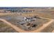 Expansive aerial view of a rural property featuring a charming home, outbuildings, and ample land near a residential community at 14624 County Road 12, Fort Lupton, CO 80621