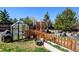 Backyard featuring a greenhouse, garden area, and lush green grass at 5241 E 128Th Way, Thornton, CO 80241