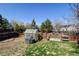 Large backyard with a fenced garden area, a greenhouse, and lush green grass at 5241 E 128Th Way, Thornton, CO 80241