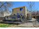 Rear exterior view of a two-story home featuring a wooden deck and a fenced yard at 5241 E 128Th Way, Thornton, CO 80241