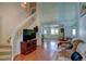 Inviting living room with a staircase, hardwood floors, and a large TV for entertainment at 5241 E 128Th Way, Thornton, CO 80241