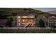 Exterior view of the home featuring a white fence, large yard, and stunning mountain views at 696 Eveningsong Dr, Castle Rock, CO 80104