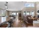 Inviting space blending kitchen and living with island seating, a dining area, and an expansive wall of windows at 696 Eveningsong Dr, Castle Rock, CO 80104