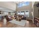 Spacious living room featuring a soaring ceiling, large windows, hardwood floors, and comfortable leather seating at 696 Eveningsong Dr, Castle Rock, CO 80104