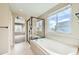 Bathroom with bathtub, shower, and large window at 5353 Royal Pine St, Brighton, CO 80601