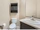 Clean bathroom with toilet, sink, and dark brown vanity at 5353 Royal Pine St, Brighton, CO 80601