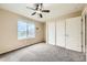 Bright bedroom with ceiling fan, window, and sliding closet doors at 5353 Royal Pine St, Brighton, CO 80601